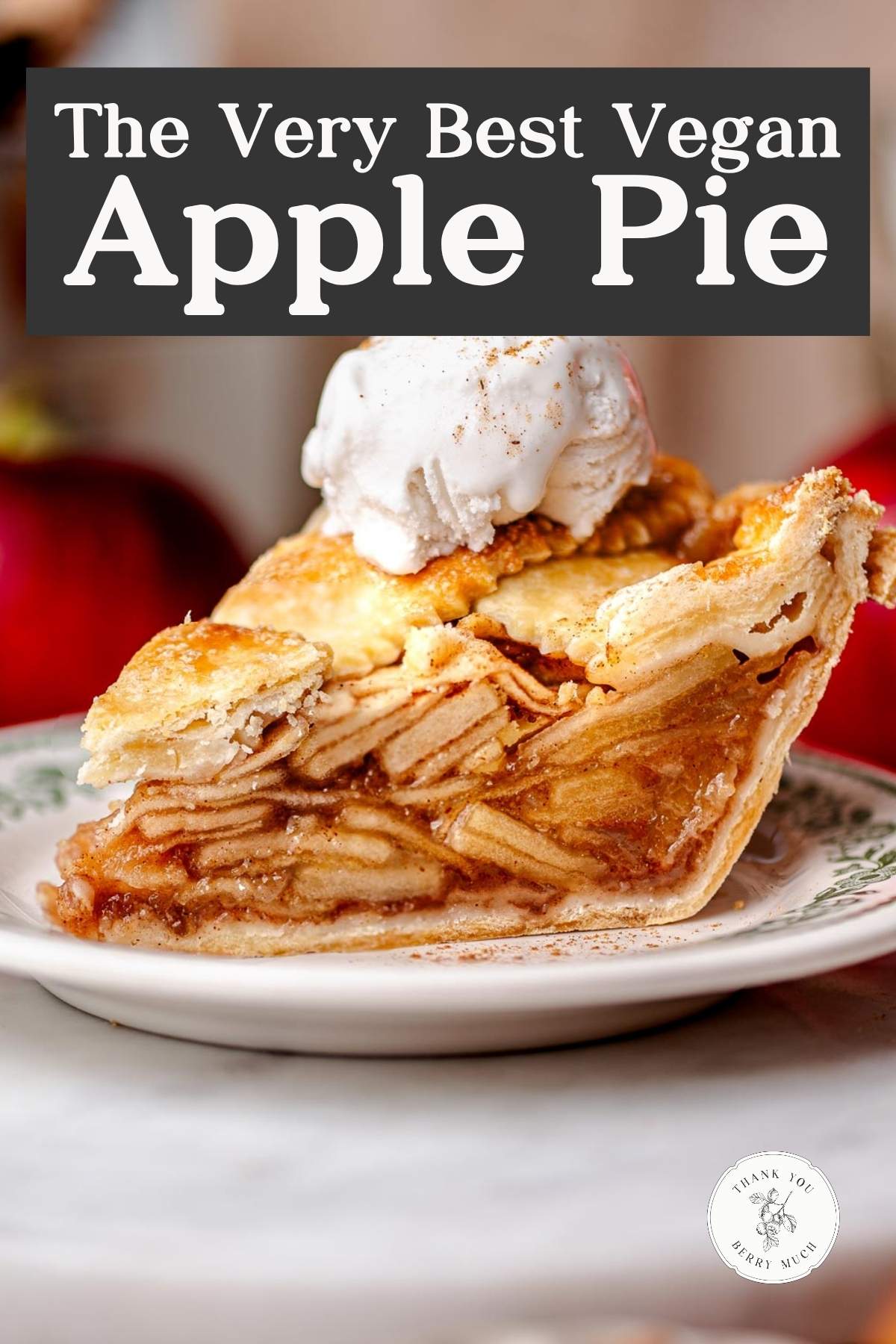 A slice of vegan apple pie with a golden flaky crust, stacked neatly with tender apple slices and topped with a scoop of vanilla non-dairy ice cream.
