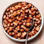 a bowl filled with marinated baked tofu.