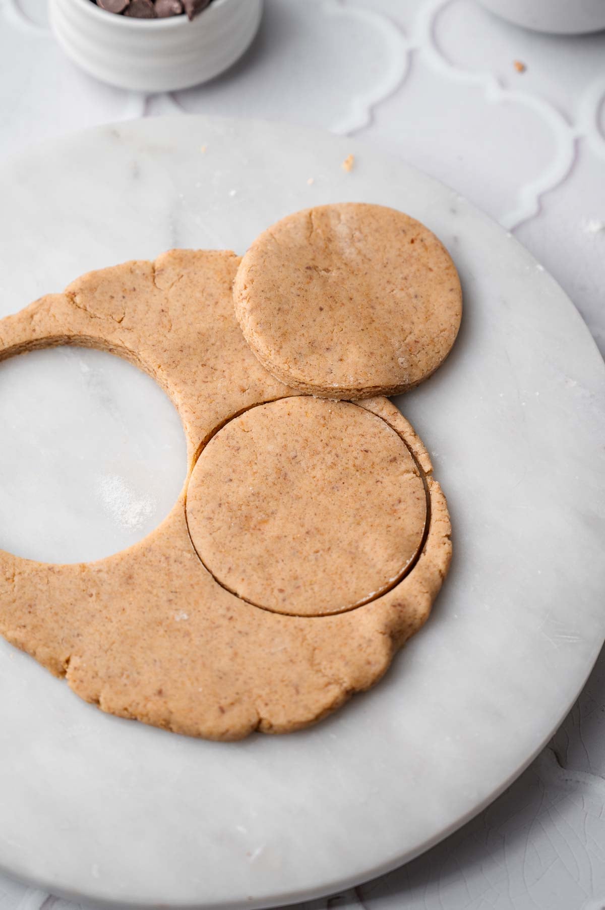 rolled out cookie dough with circular cookies cut out.