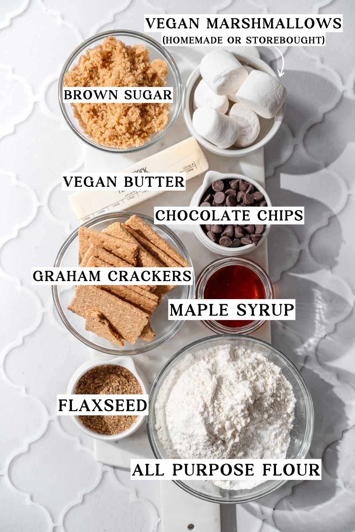 ingredients like vegan butter, marshmallows, and graham crackers on a marble tray.