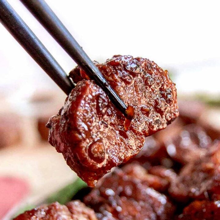 vegan beef tip made of seitan being held by chopsticks.