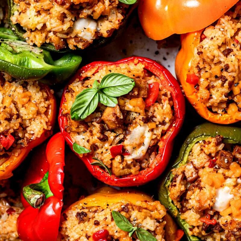 vegan stuffed peppers filled with rice, dairy free cheese, baked tofu, and beyond meat.