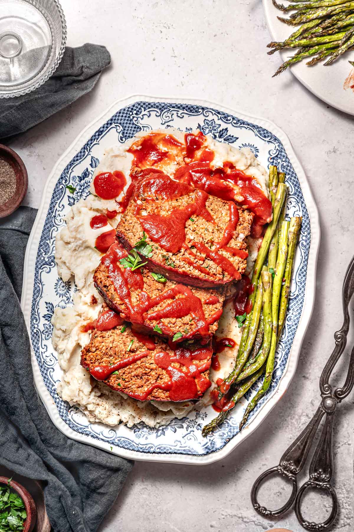 three slices of vegan meatloaf made with Beyond Meat on a bed of mashed potatoes.