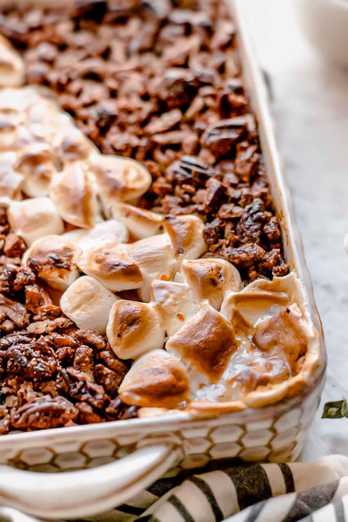 vegan sweet potato casserole topped with candied pecans and marshmallows.
