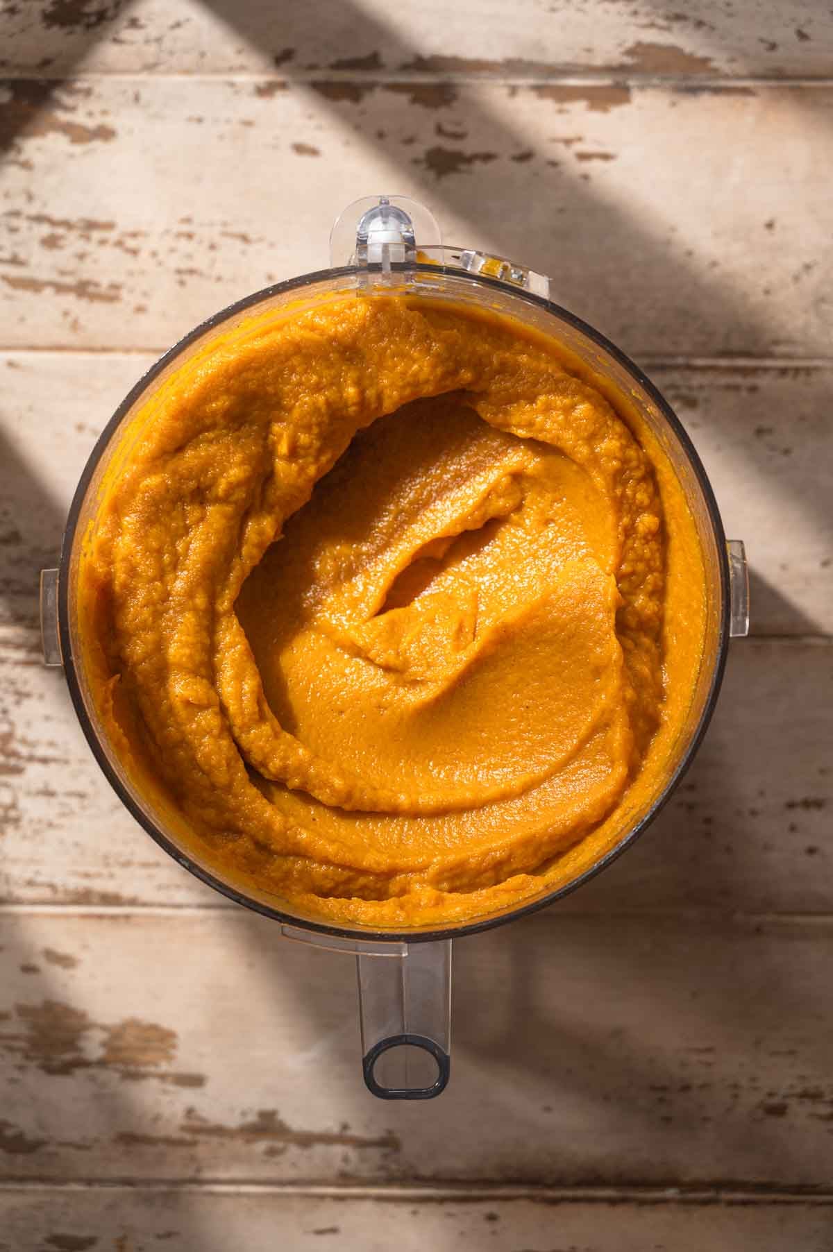 the blended sweet potato casserole filling in a food processor bowl.