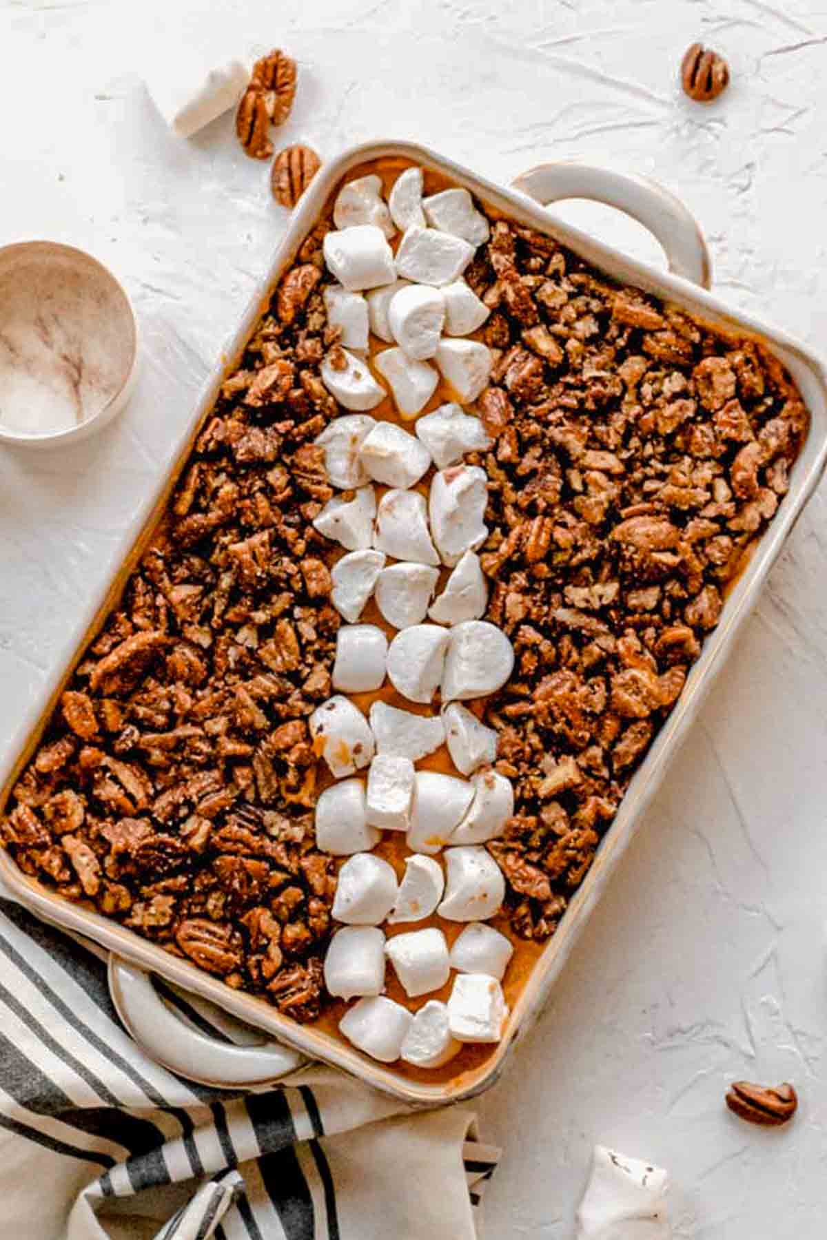 the sweet potato casserole in a baking dish with vegan marshmallows and pecans.