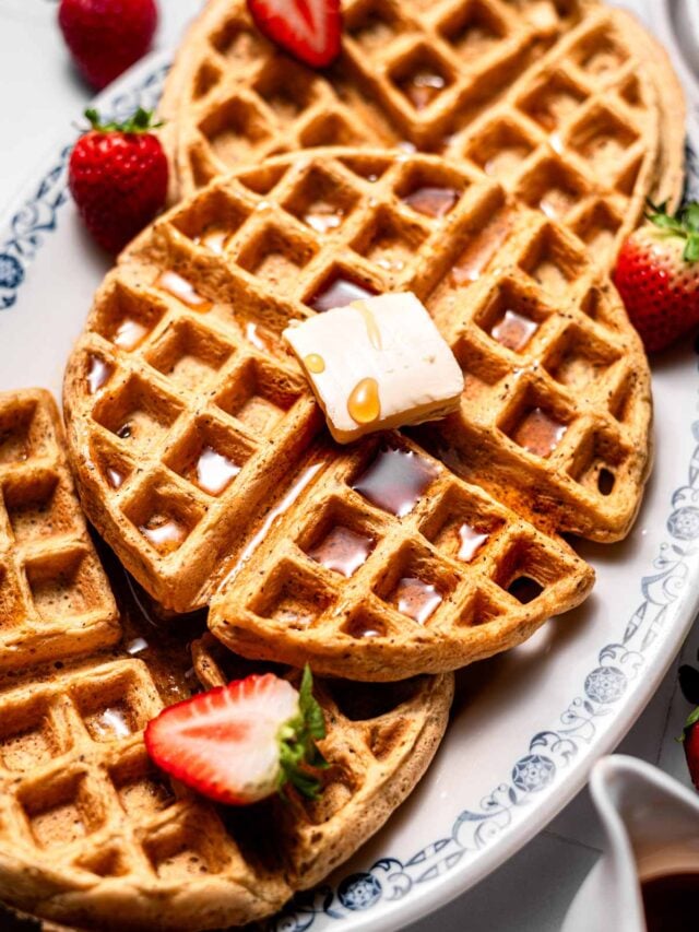 crispy vegan waffles with a pat of dairy free butter and syrup on top.