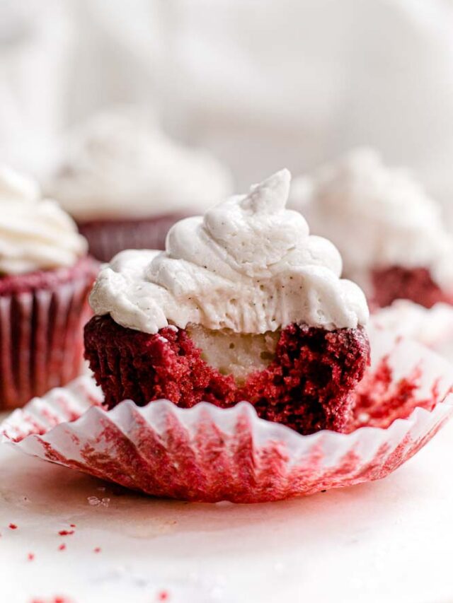 Focus shot on a Vegan Red Velvet Cake with Cream Cheese Frosting. A portion of the cake has been taken out to reveal its inner layers