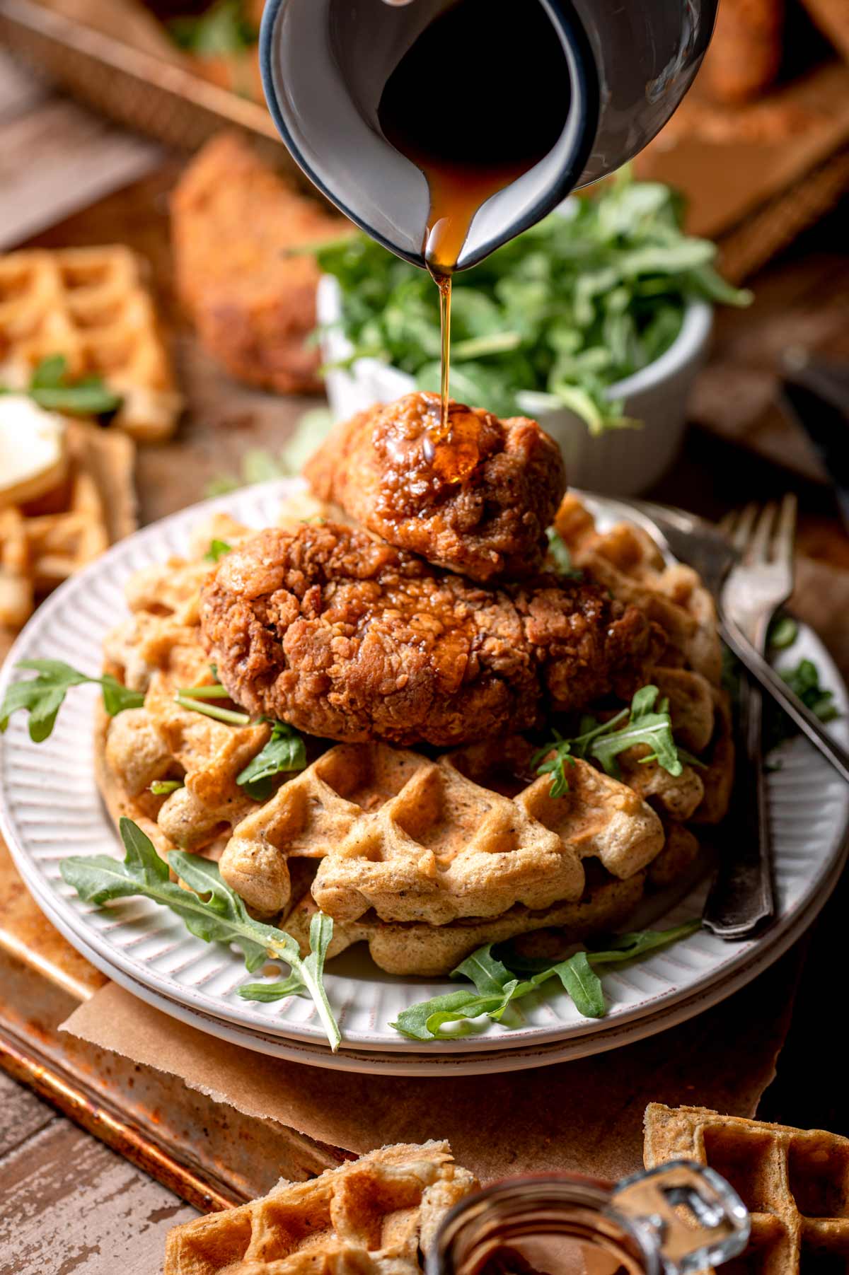 two vegan chicken drumsticks on a stack of waffles with syrup.