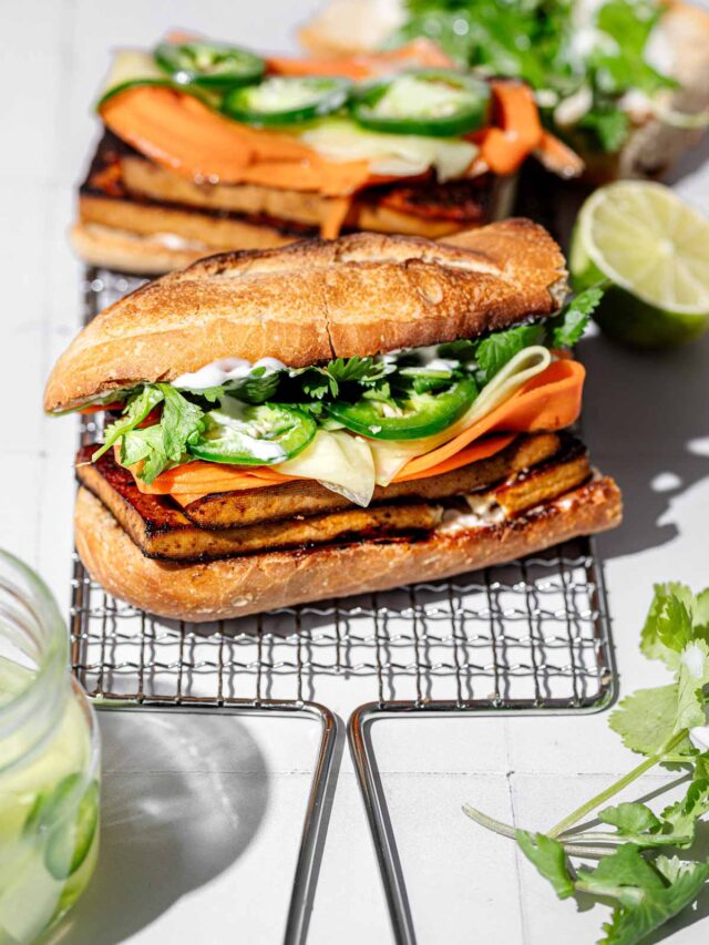 a vegan tofu banh mi sandwich on a wire rack.