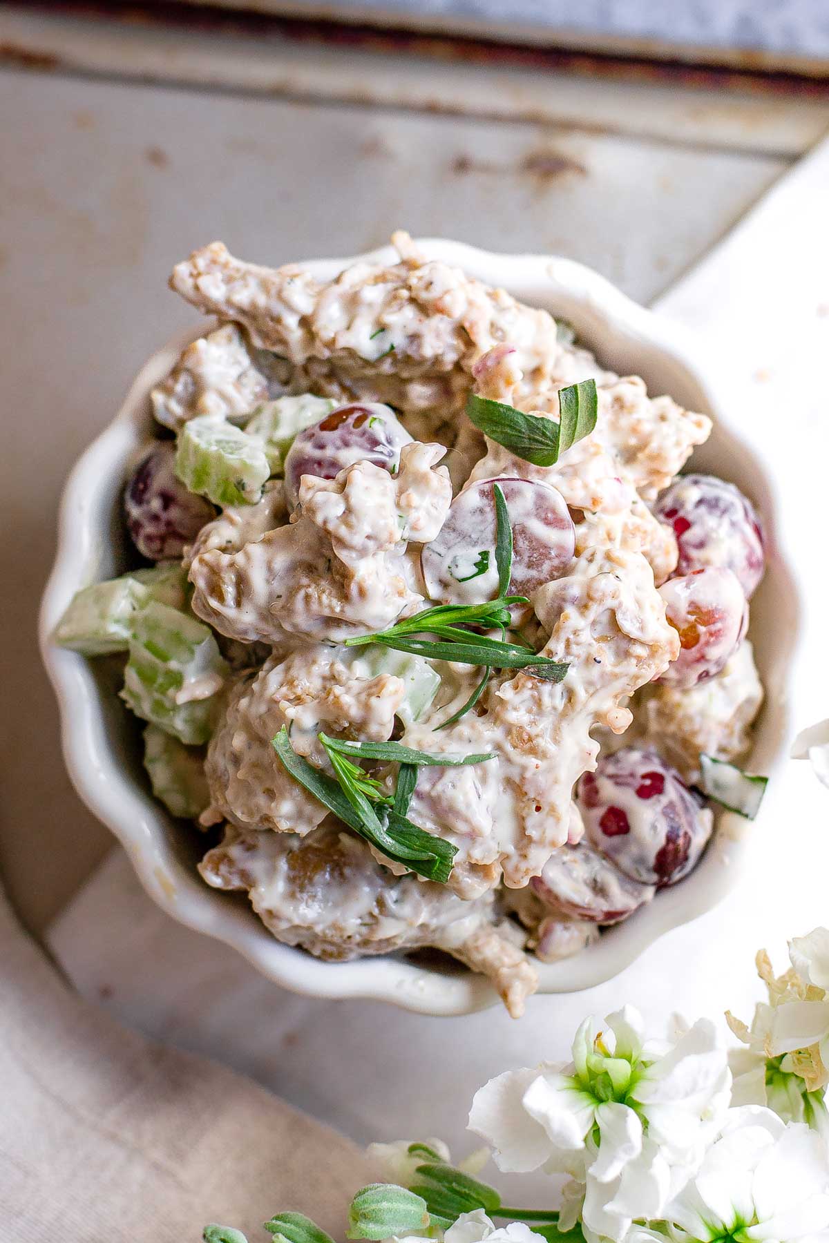 creamy vegan seitan chicken salad in a bowl topped with tarragon.