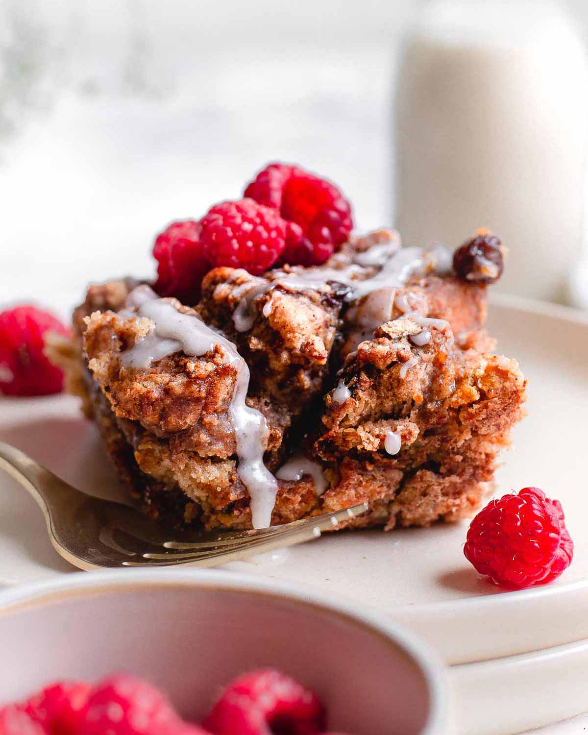 the french toast casserole on a plate with raspberries.