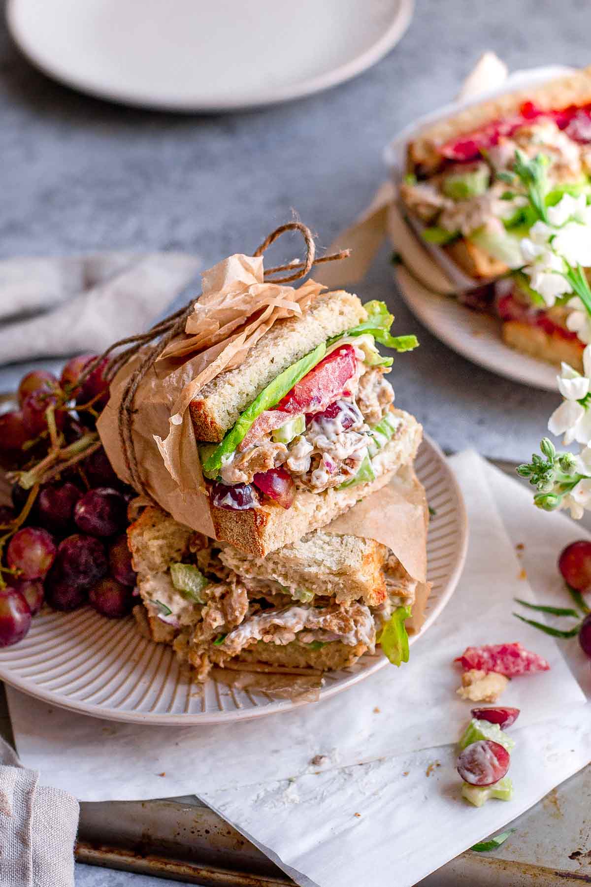 the vegan chicken salad in a sandwich with sourdough, tomatoes and lettuce.