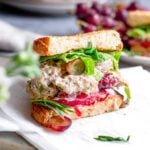 vegan chicken salad inside a sourdough sandwich with tomato and butter lettuce.