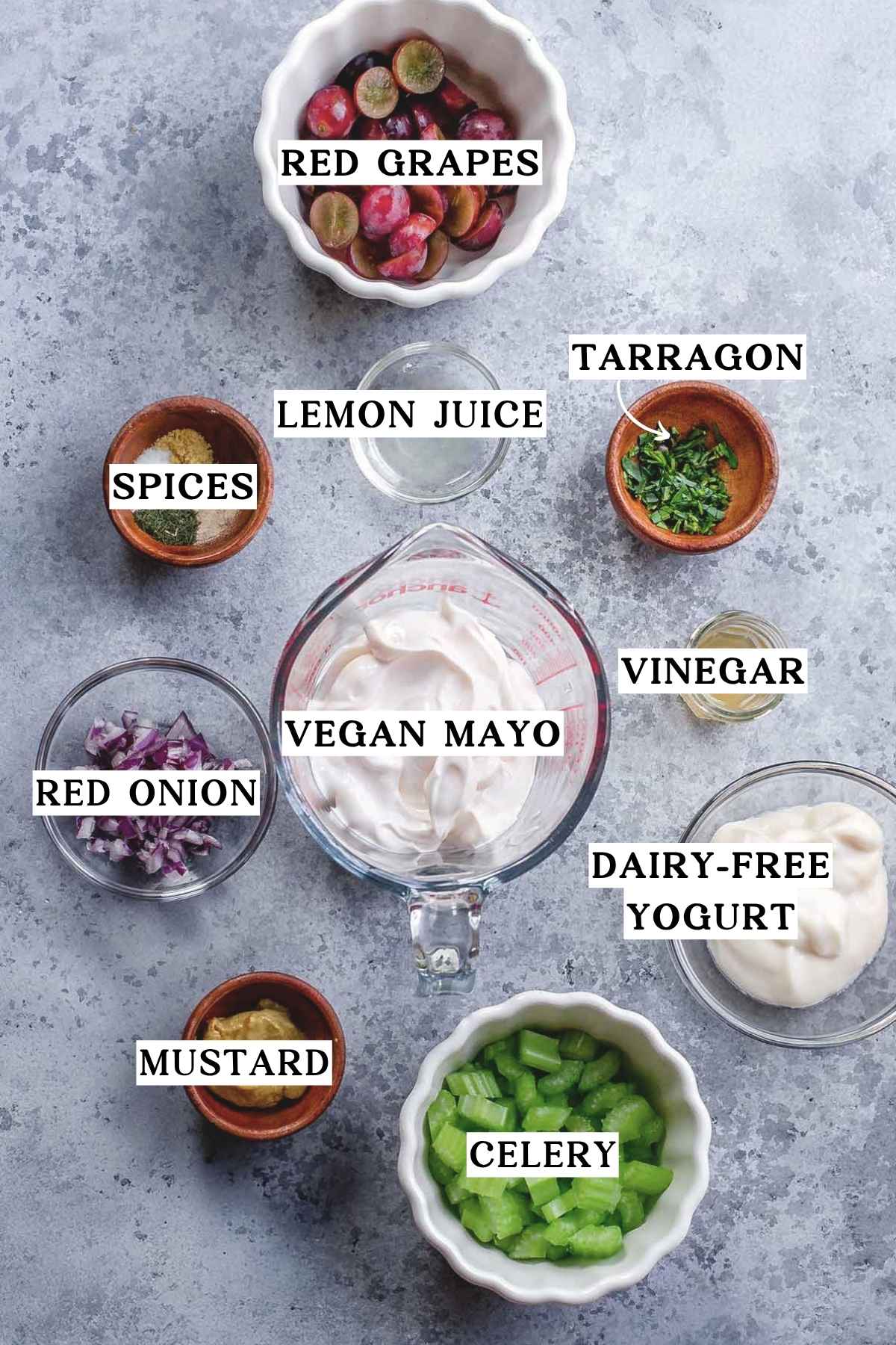 vegan mayo, celery, grapes, onion and herbs on a blue counter.