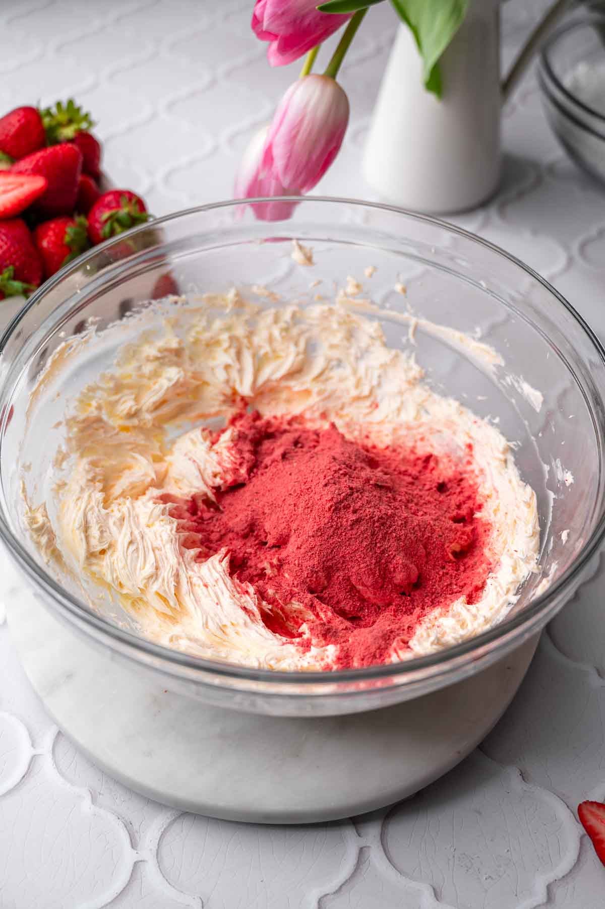 the softened vegan butter beaten in a large bowl with the blended freeze dried berries on top.