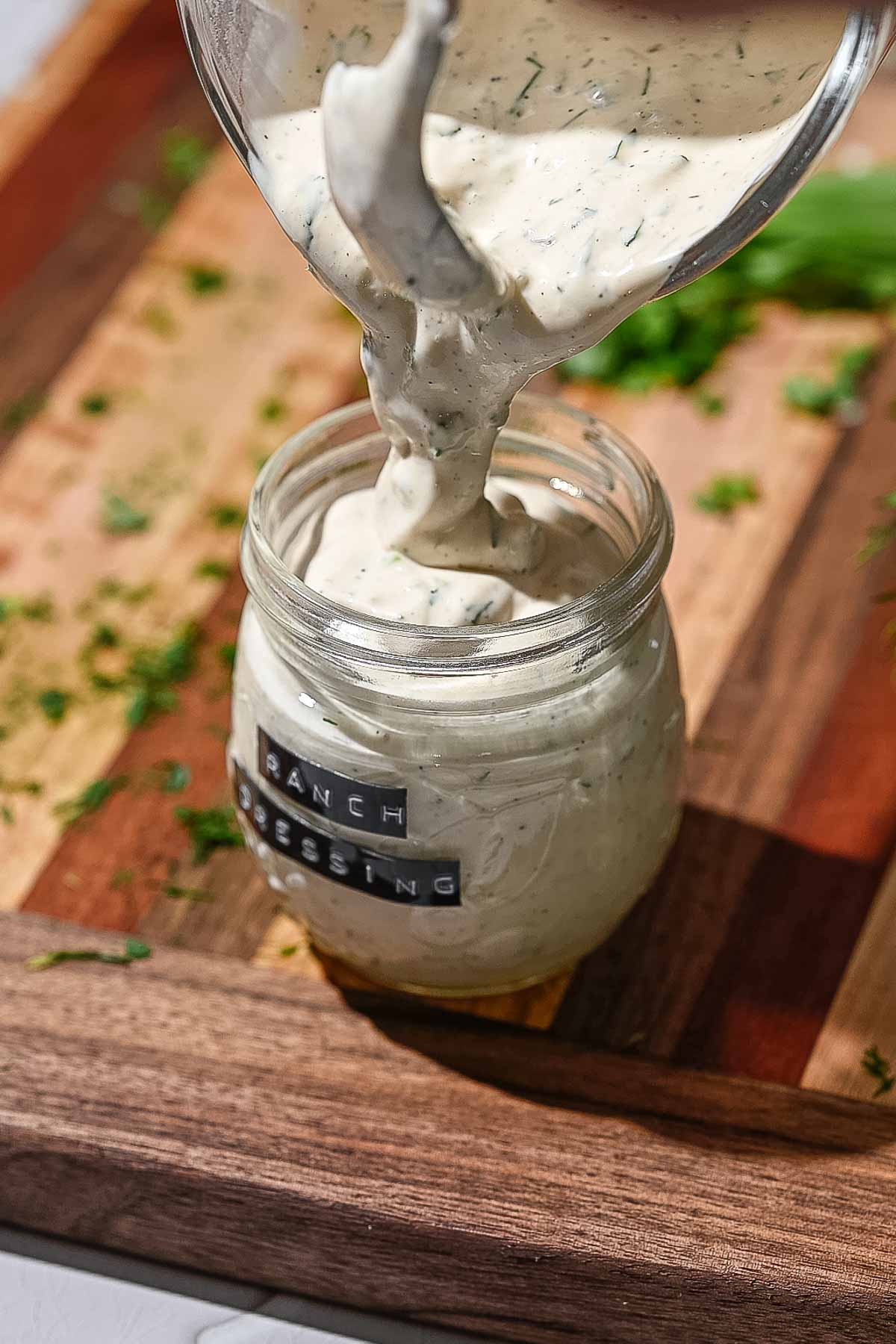 the ranch being poured into a glass jar.