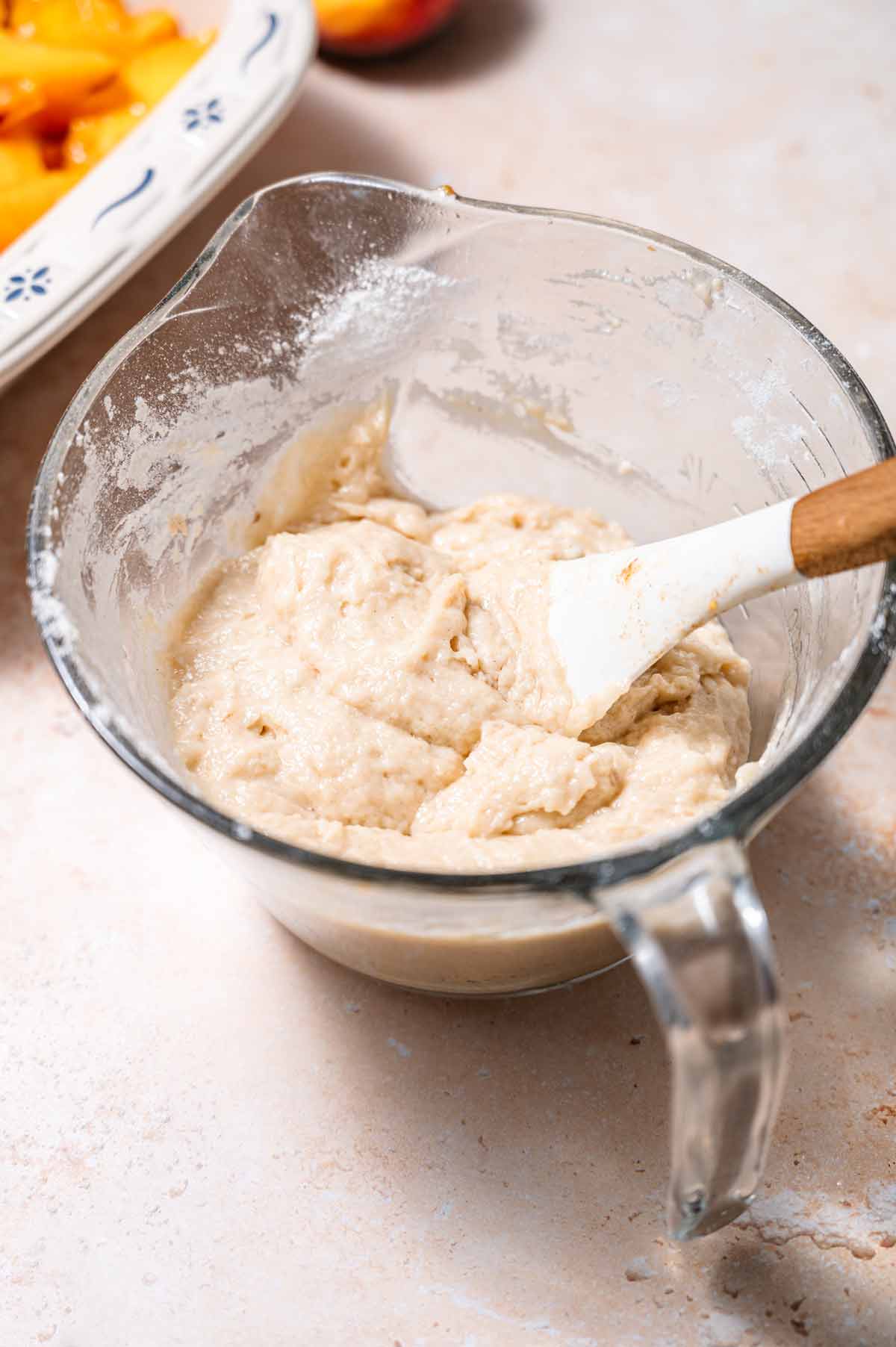 a large glass measuring cup with the cobbler batter.