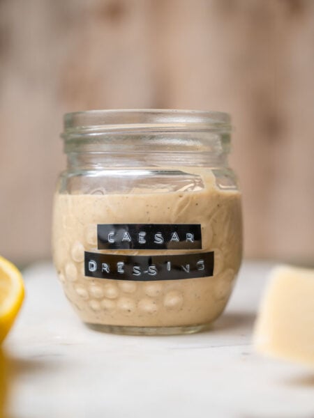 a jar of vegan caesar dressing with a vintage label on the front.