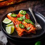 two vegan enchiladas on a plate topped with melted dairy-free cheese.