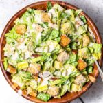 vegan caesar salad in a wooden bowl.