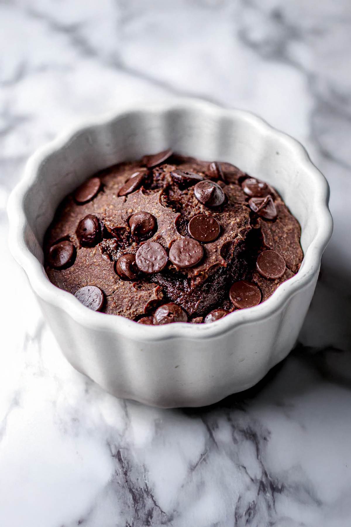 a ramekin with nutella baked oats with chocolate chips.