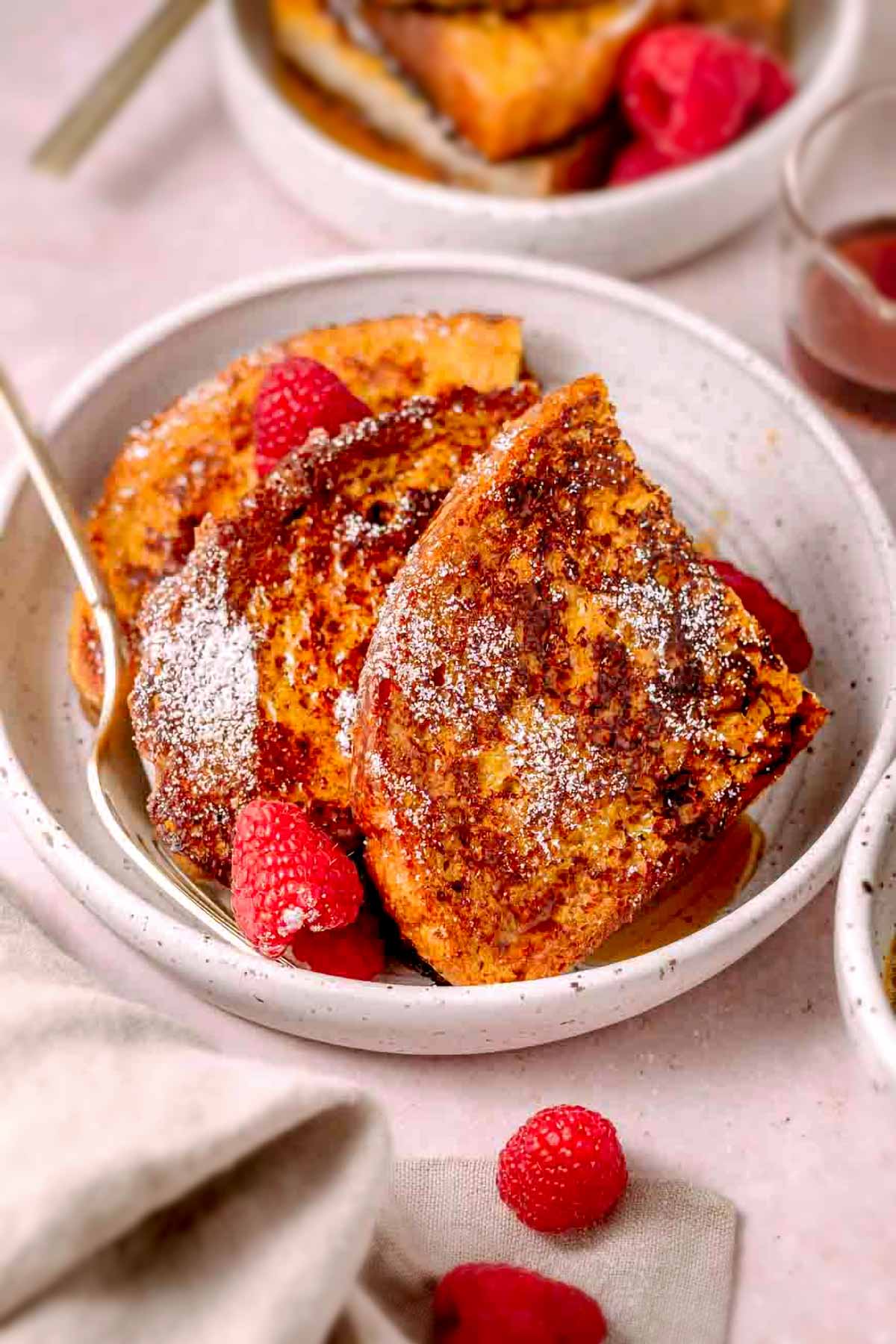 slices of JUST egg french toast on a plate with raspberries.