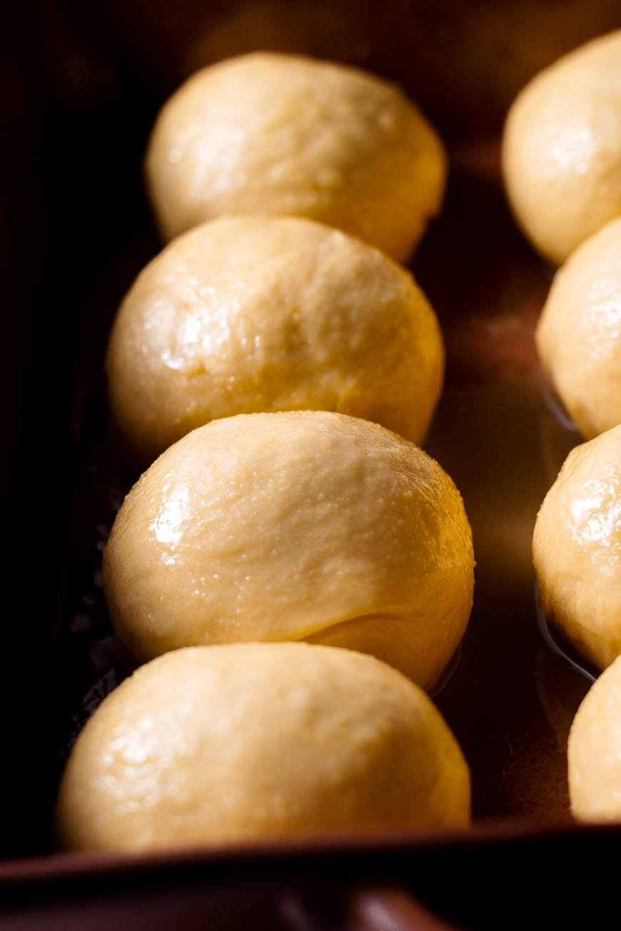 vegan brioche buns in a pan with egg wash.