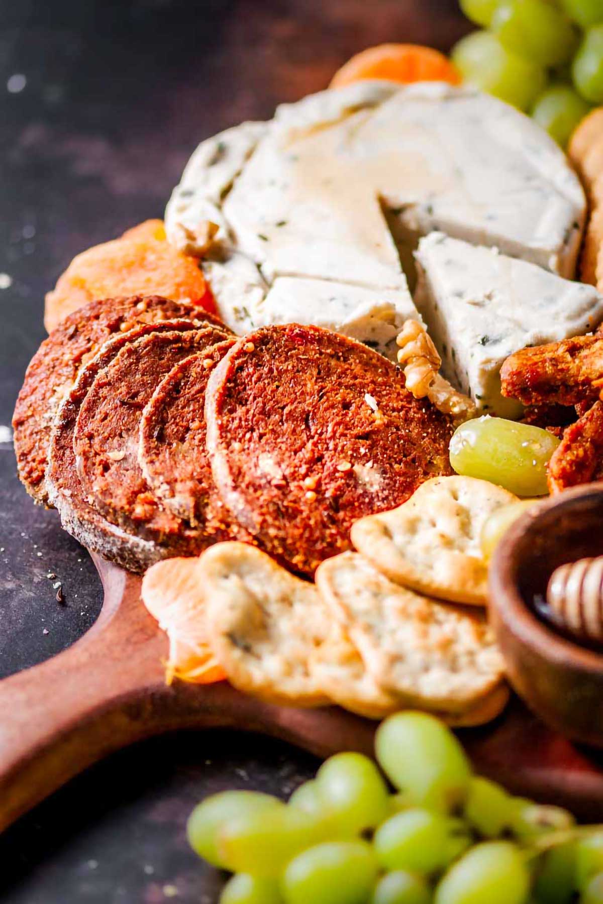 slices of vegan salami on a charcuterie board.