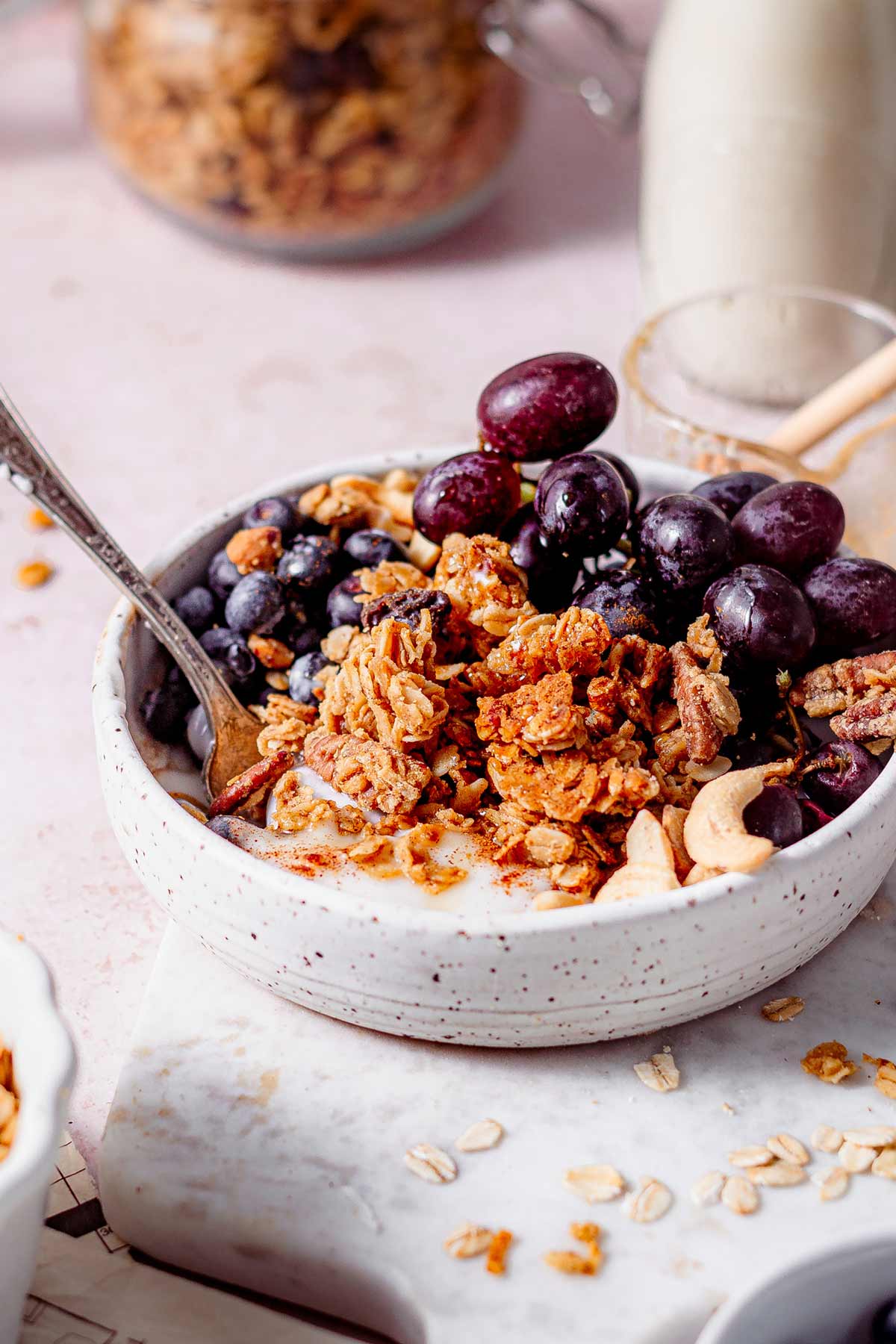 air fryer granola in a bowl with grapes and yogurt.