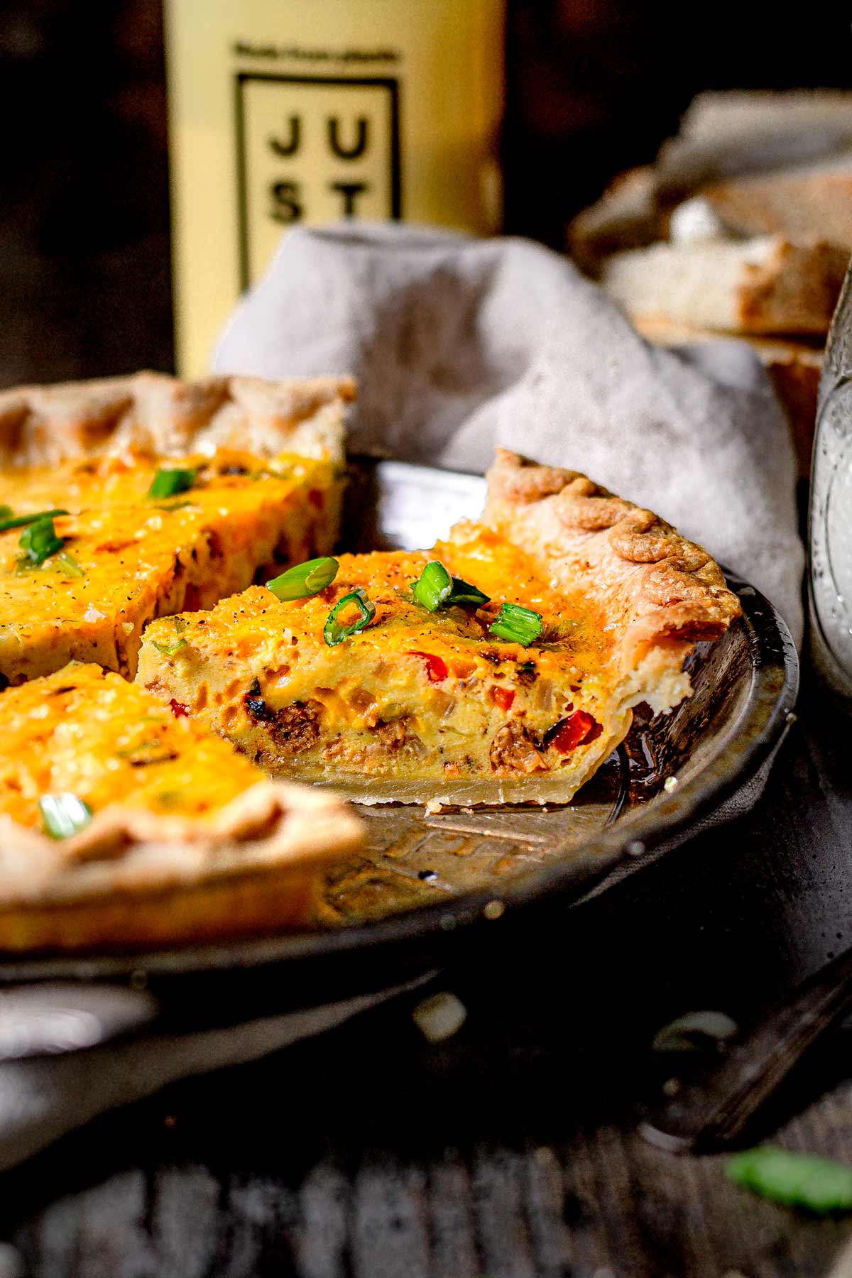 Close-up of vegan Just Egg quiche with plant-based sausage and red bell peppers baked into a flaky golden crust.