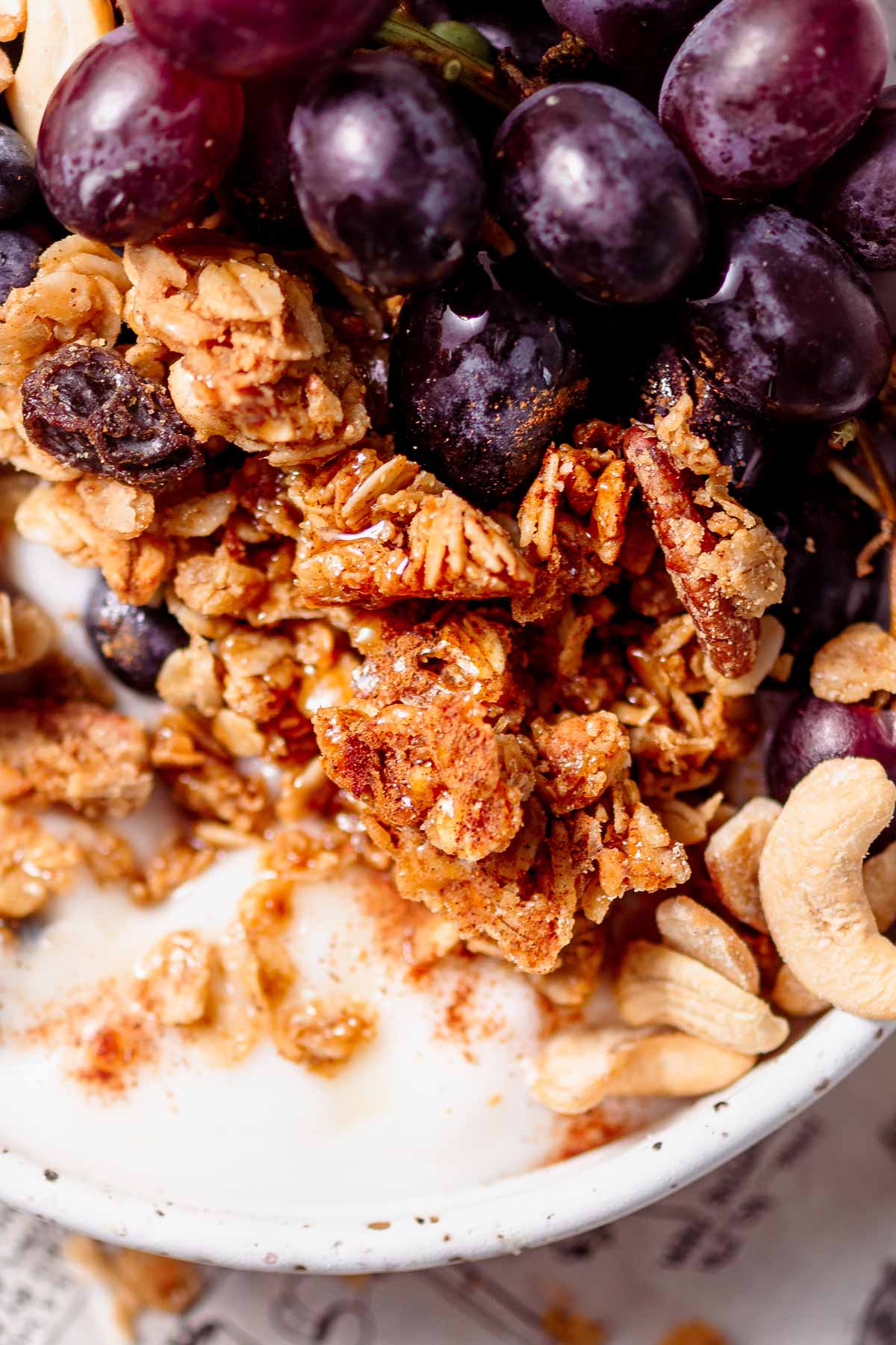 big clusters of air fryer granola in a bowl with dairy-free yogurt.
