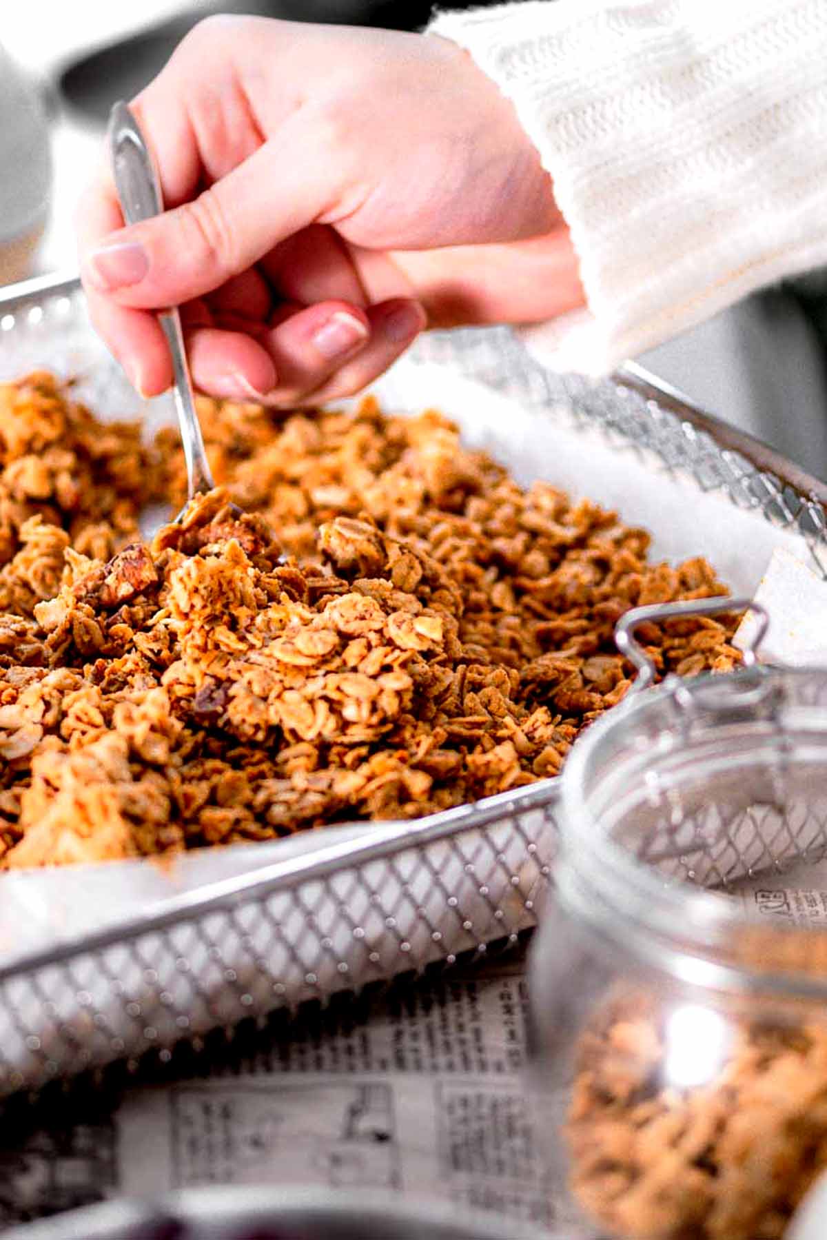 a hand breaking the air fryer granola into chunks.