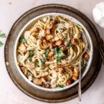 creamy lemon garlic tahini pasta with kale in a white ceramic dish.