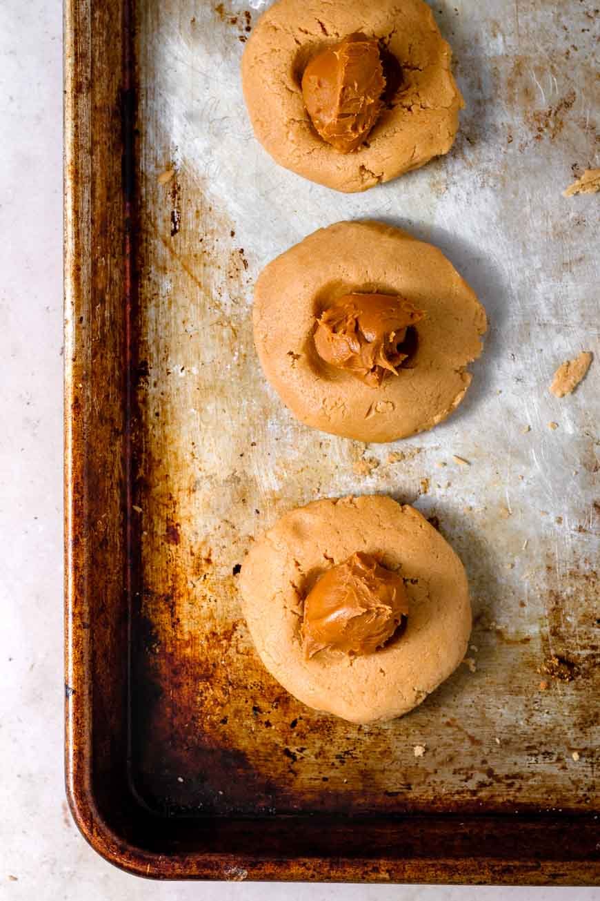 a ball of frozen cookie butter pressed into biscoff cookie dough.