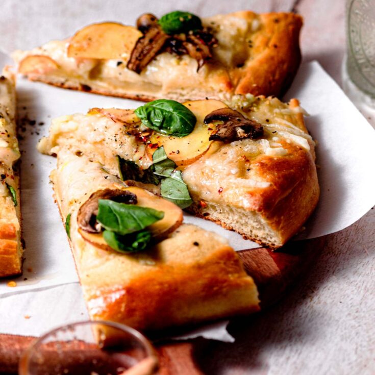 vegan white pizza with potato, mushrooms and basil.