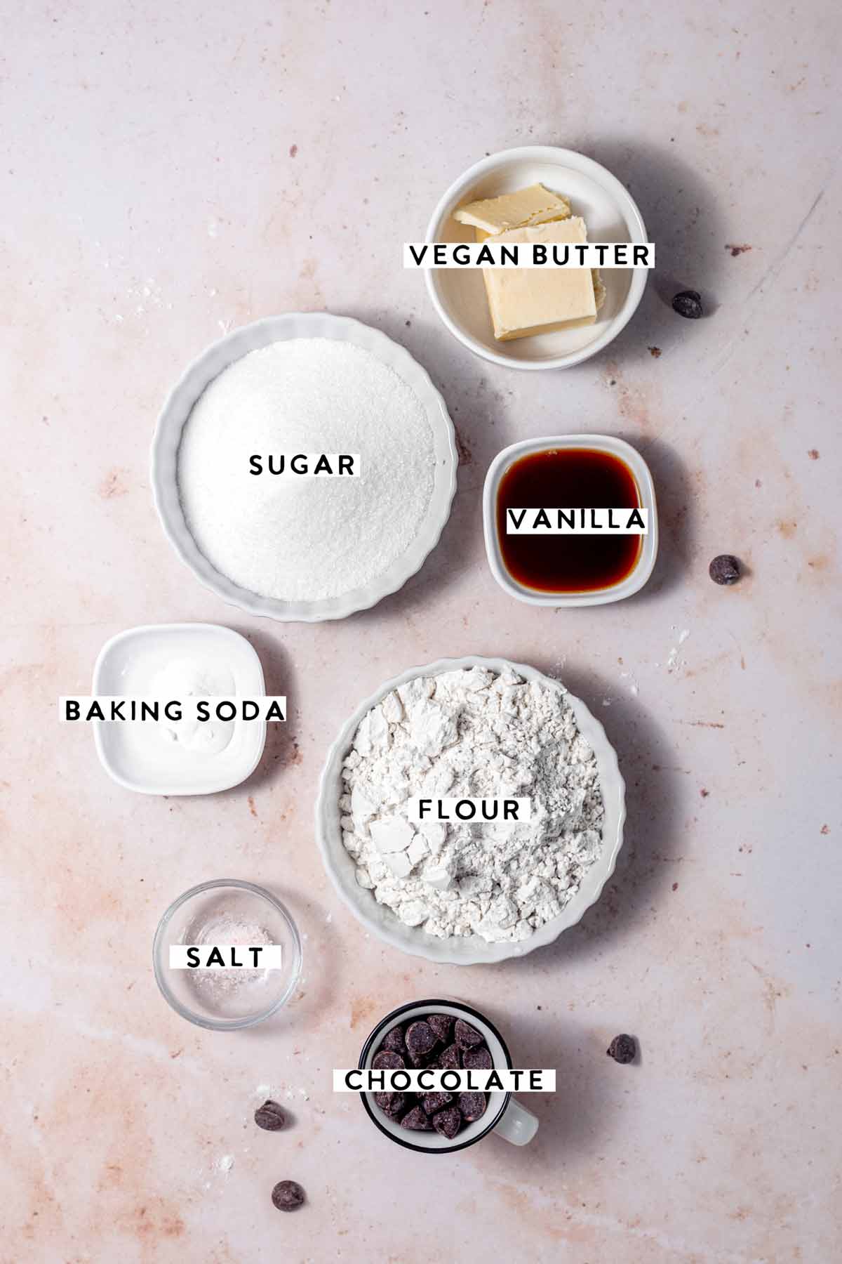 ingredients like sugar, butter, chocolate chips on a stone background.
