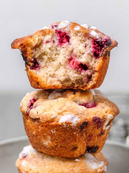 three vegan raspberry muffins stacked on each other.