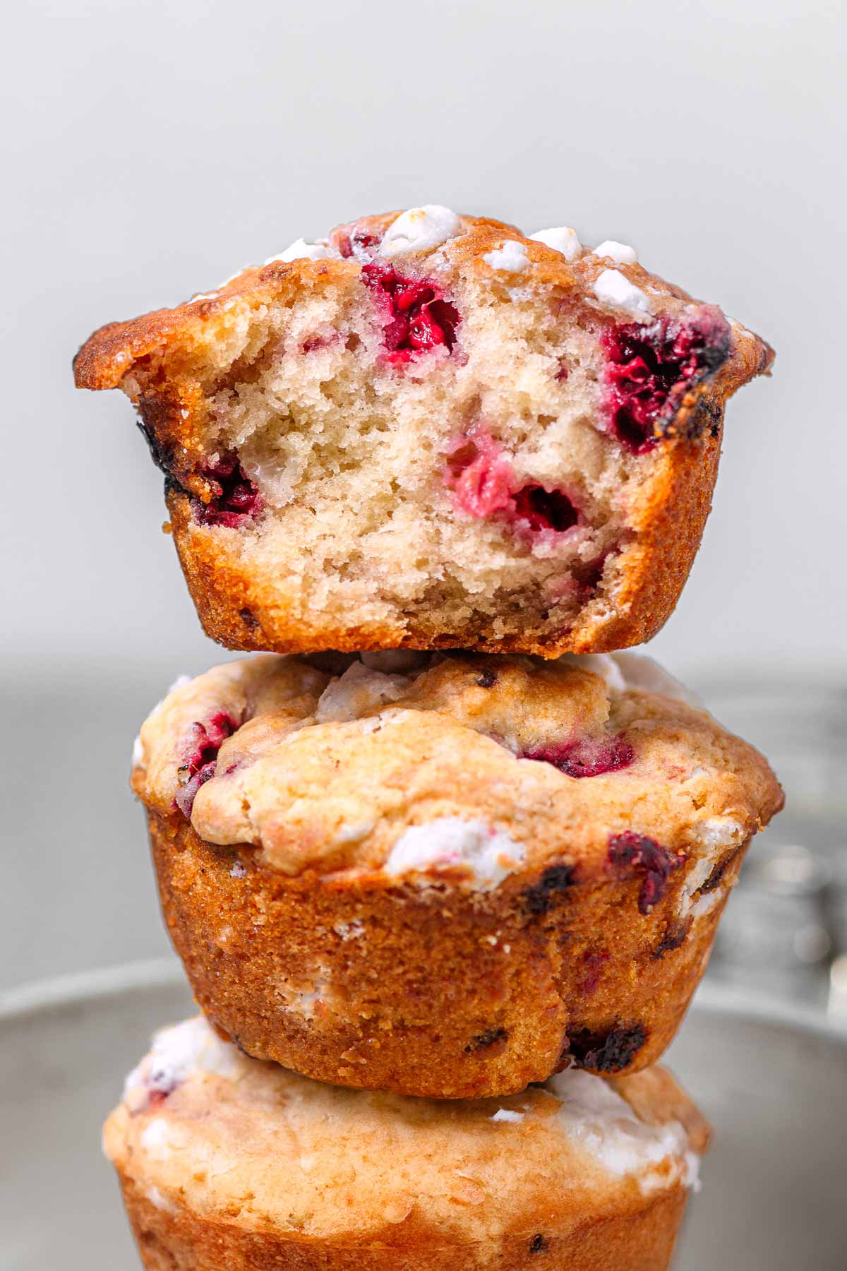 three vegan raspberry muffins stacked on each other.