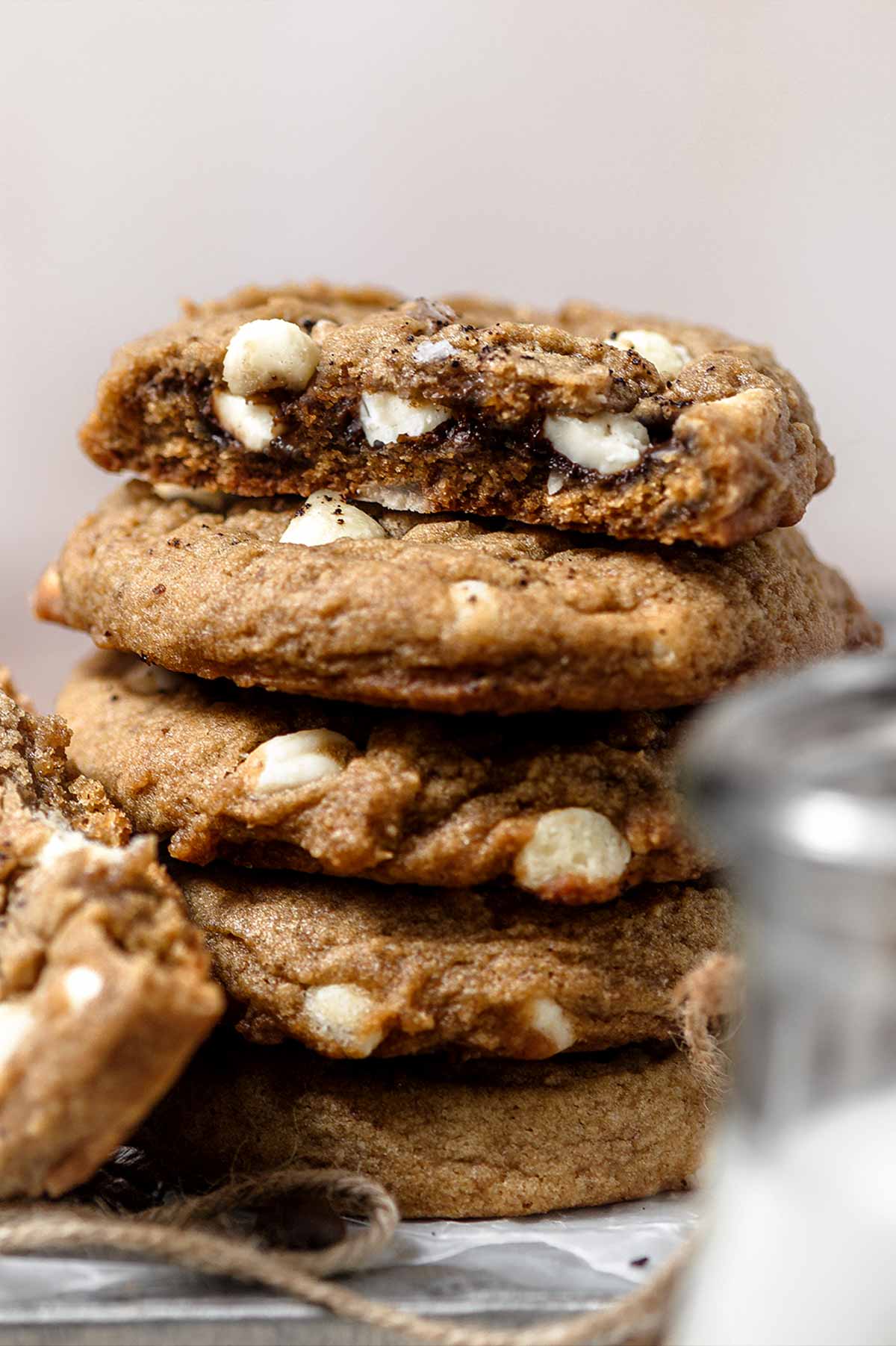 a fudgy vegan coffee cookie broken in half with white chocolate chips.