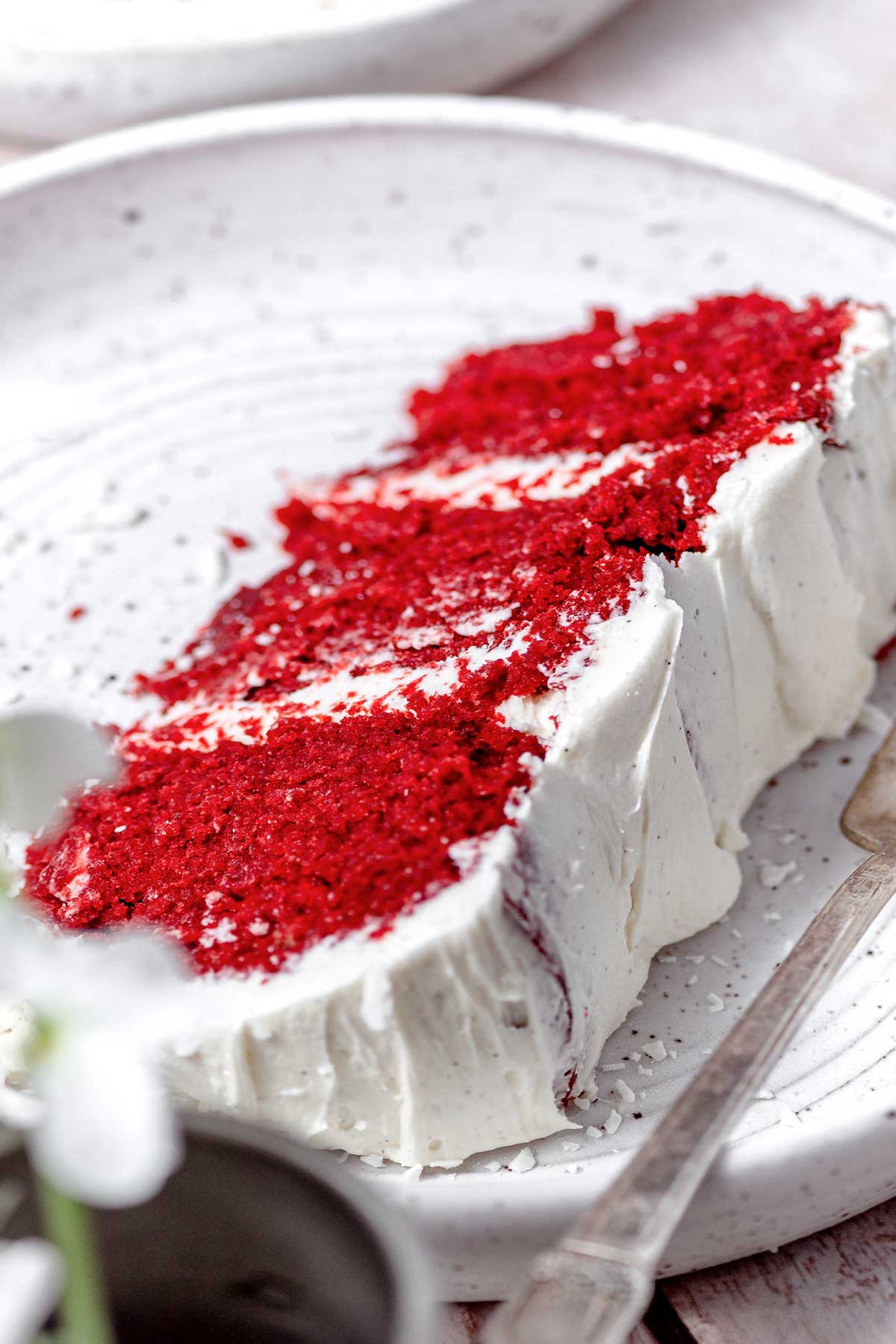slice of eggless red velvet cake with vegan cream cheese frosting.