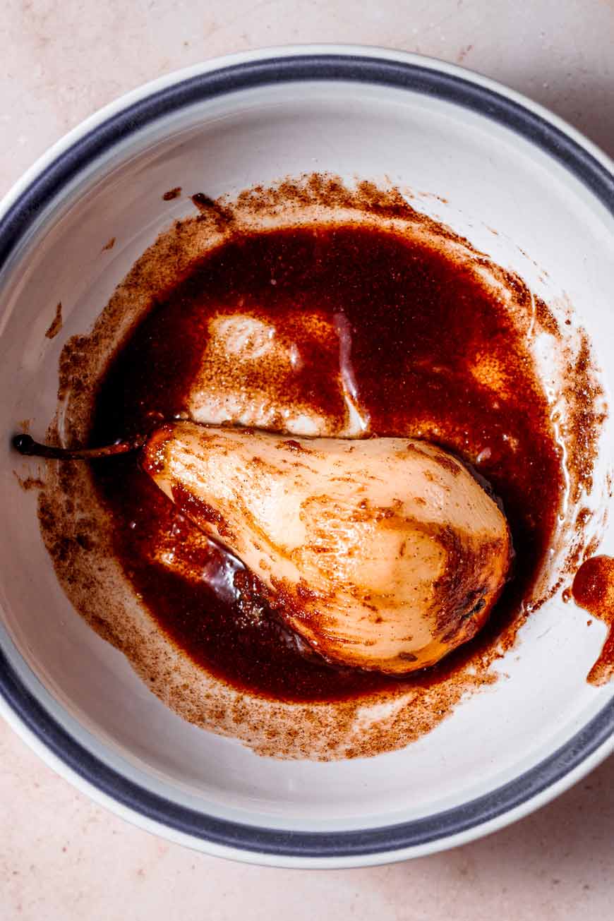 a pear half coated in melted butter and brown sugar.