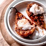 healthy air fryer pear with cinnamon crisp topping and whipped cream.
