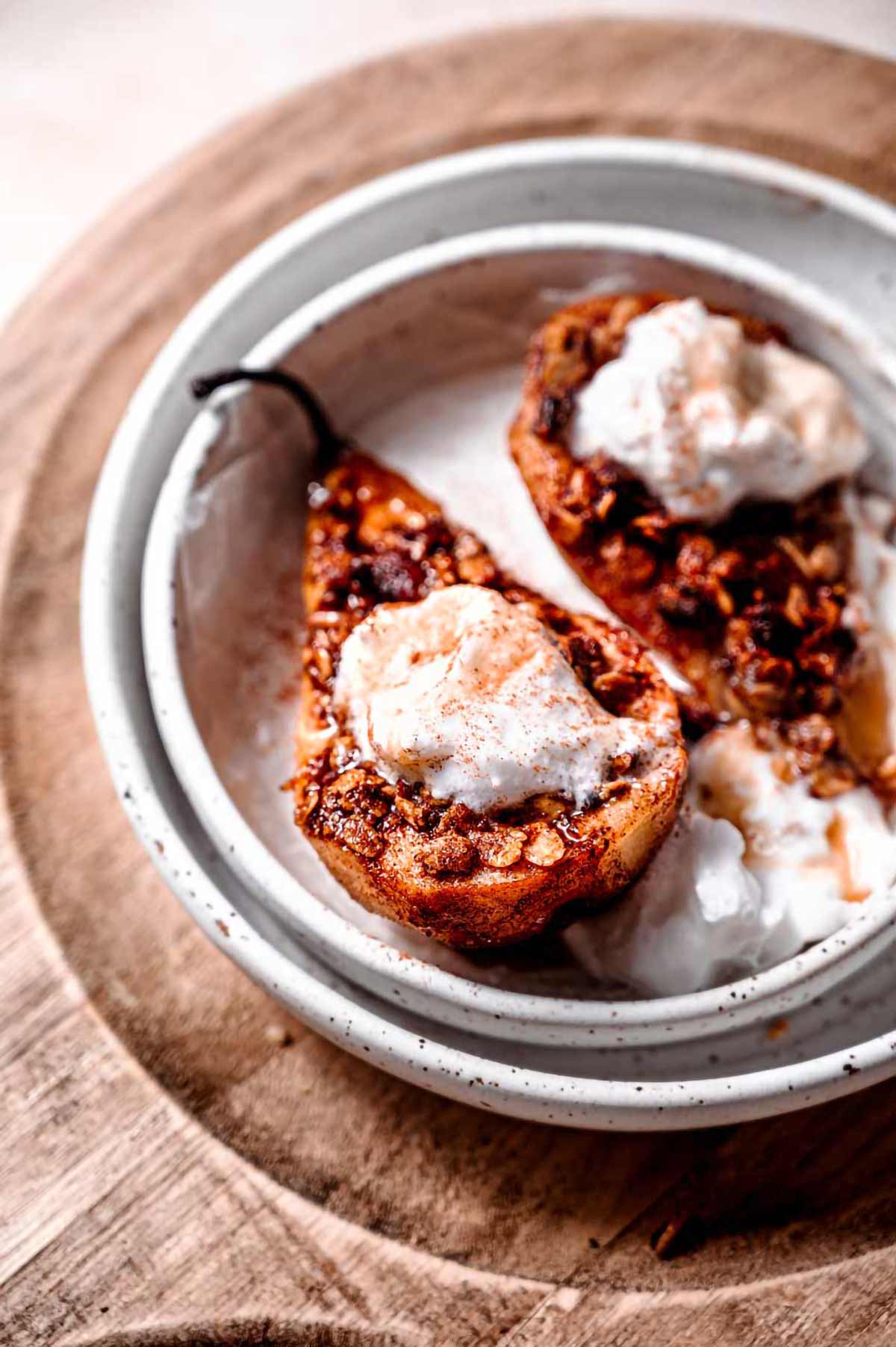 healthy air fryer pear with cinnamon crisp topping and whipped cream.