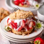 homemade vegan strawberry shortcake on a stack of white dessert plates.