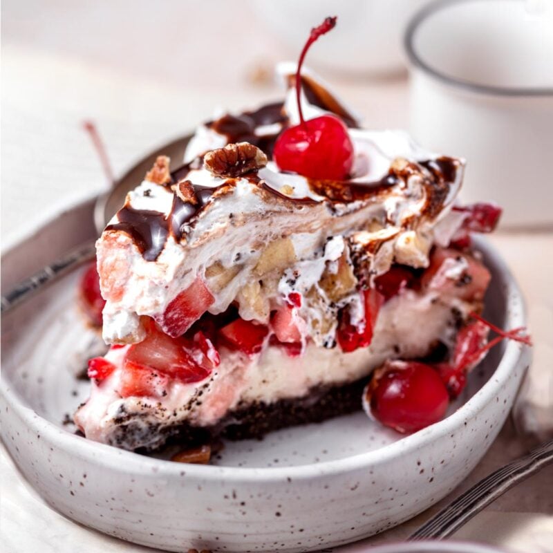 a slice of banana split pie in a small ceramic plate.
