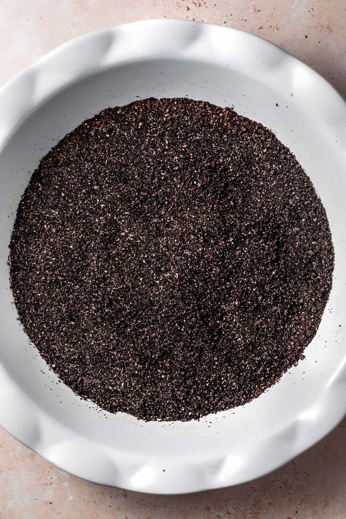 the dark chocolate cookie crust pressed into a white pie dish.