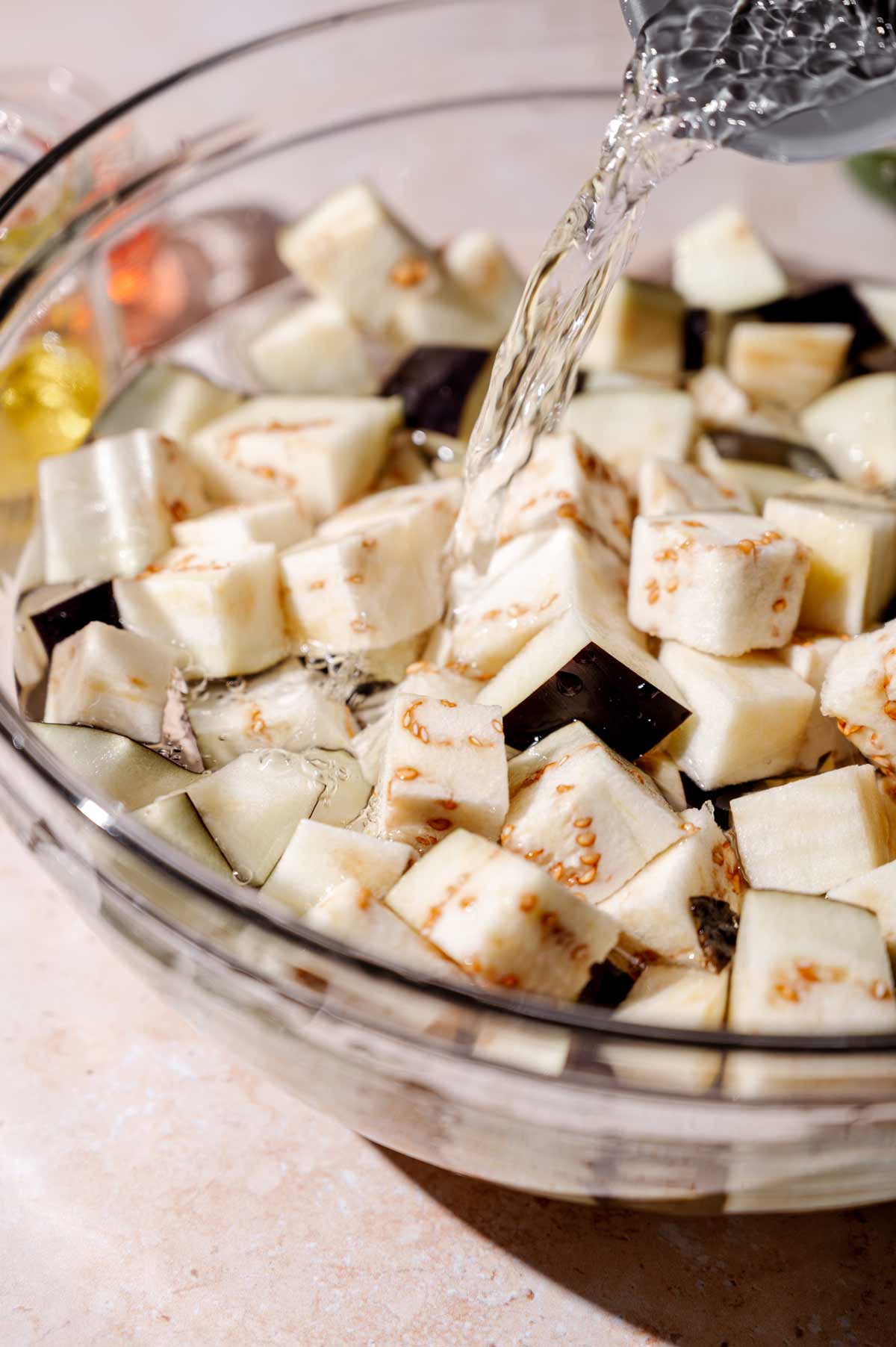 pouring water on the eggplant cubes.