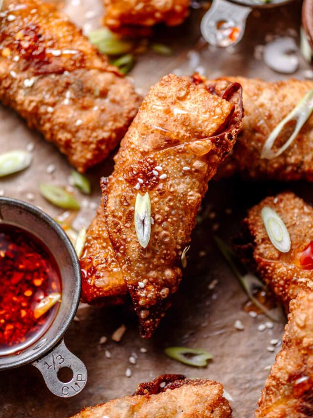 crispy vegan egg rolls with a veggie and tofu filling on parchment paper.
