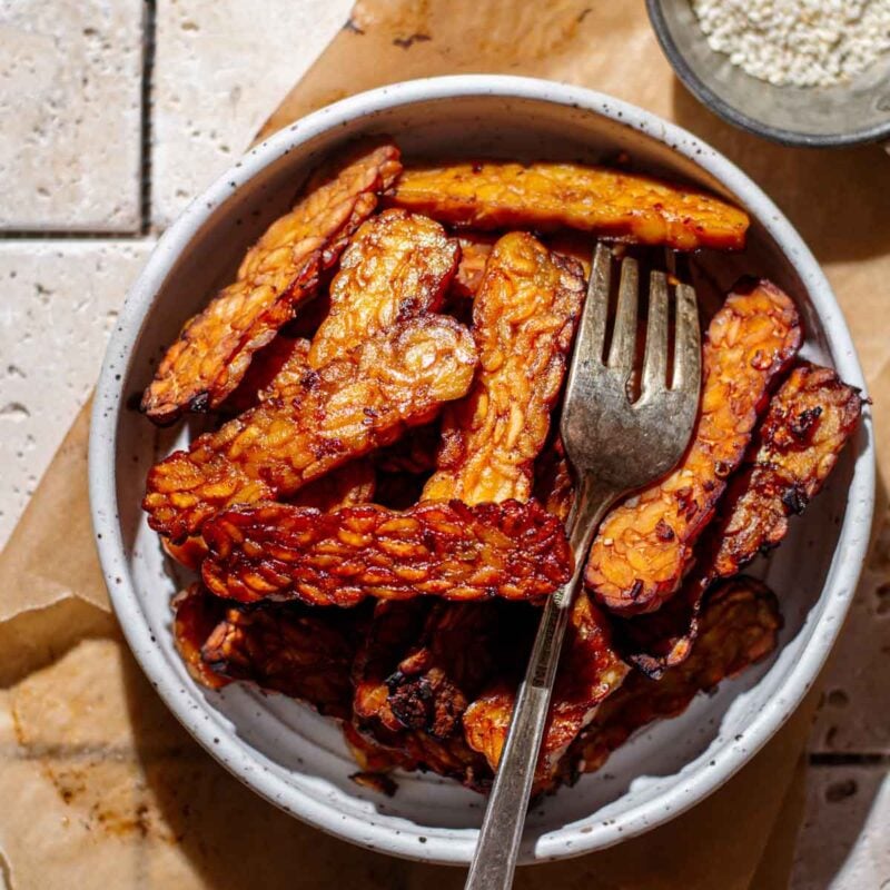 pan fried tempeh in a small white bowl.